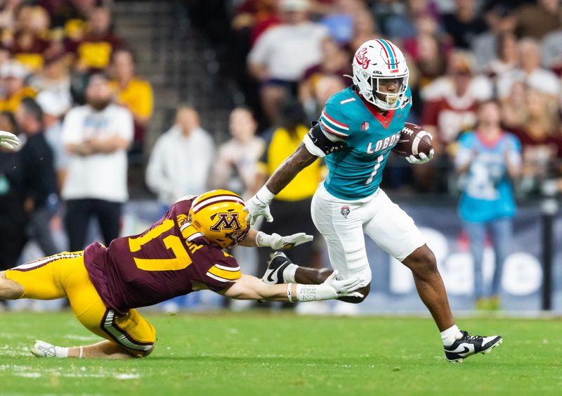 Dec 26, 2025; Phoenix, AZ, USA; New Mexico Lobos running back Damon Bankston (1) against Minnesota Gophers defensive back John Nestor (17) during the first half of the Rate Bowl at Chase Field. Mandatory Credit: Mark J. Rebilas-Imagn Images