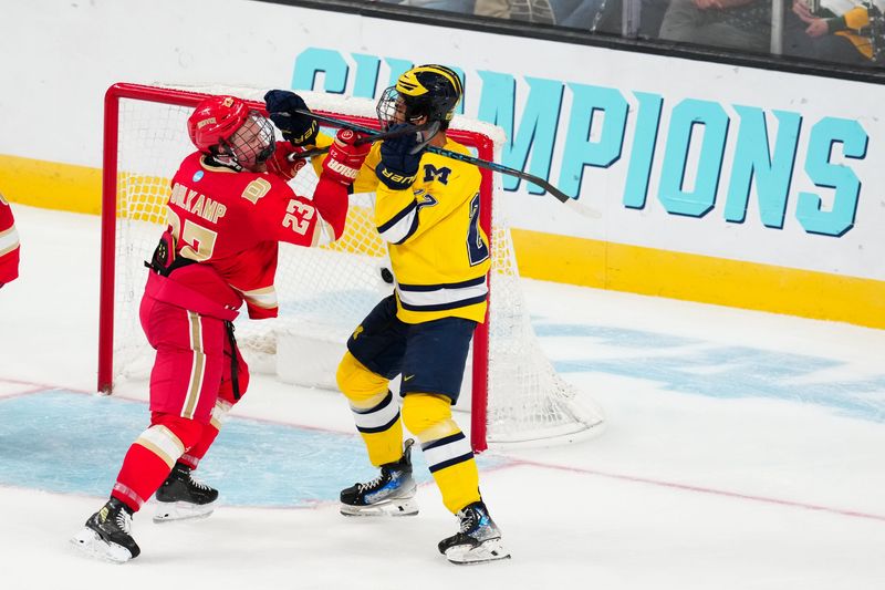 Denver defenseman Eric Pohlkamp (23) checks Michigan forward Malcolm Spence (27) during the semifinals of the NCAA men's ice hockey Frozen Four at T-Mobile Arena.  Pohlkamp could be this year’s winner of the Hobey Baker Award.