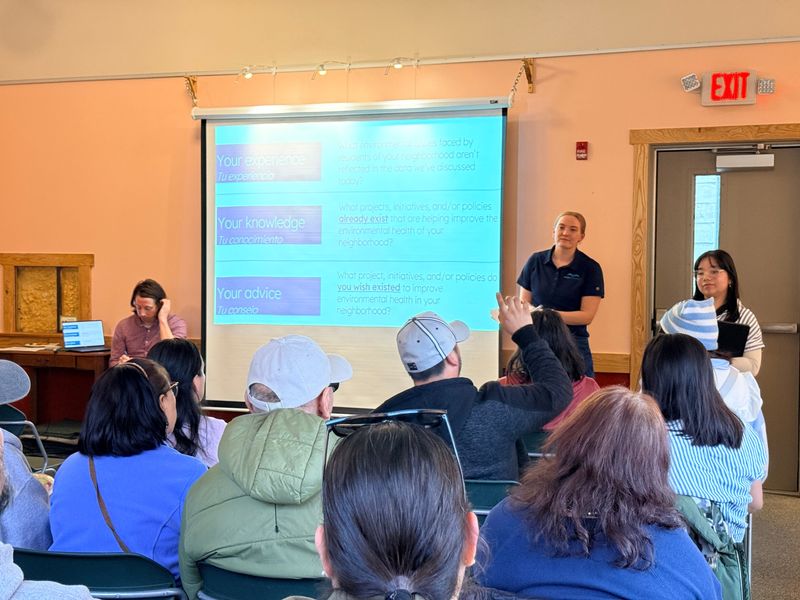 Kayla Rinderknecht (front middle) and Nancy Retana of Clean Wisconsin present an analysis of environmental health risks to residents of Milwaukee's Silver City, Burnham Park and Muskego Way neighborhoods at the Urban Ecology Center's Menomonee Valley location March 31. Clean Wisconsin is working with neighborhoods across the city to help them understand local risks and find solutions.