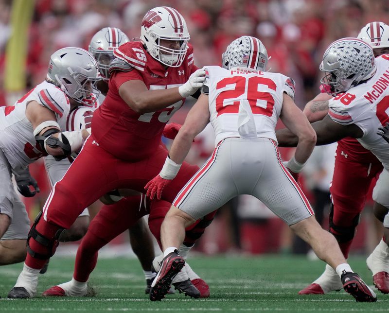 Oct 18, 2025; Madison, Wisconsin, USA;Wisconsin offensive lineman Emerson Mandell (75) blocks Ohio State linebacker Payton Pierce (26) during the fourth quarter at Camp Randall Stadium. Mandatory Credit: Mark Hoffman-USA TODAY Network via Imagn Images