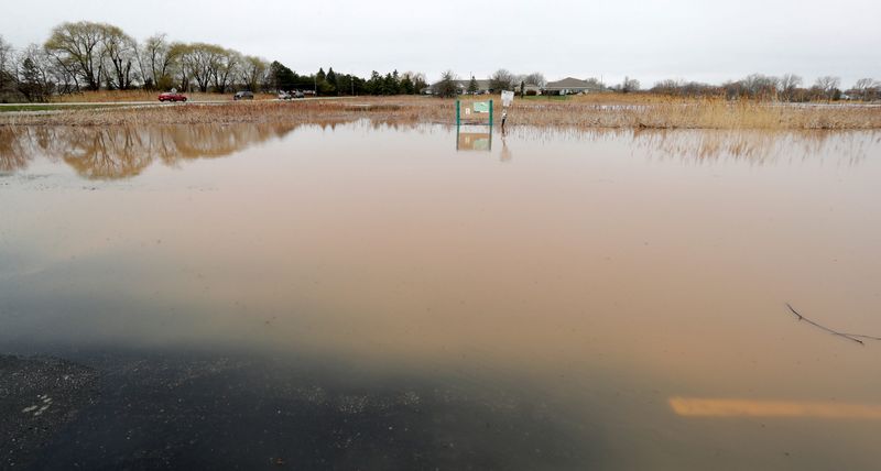 The parking lot of The Rite Place near the East River Trail is flooded after heavy storms on April 14, 2026, in Bellevue, Wis.