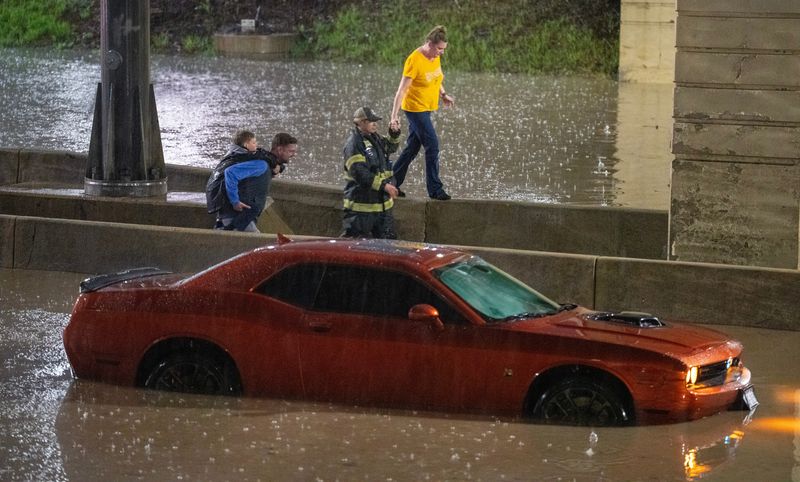 Firefighters and law enforcement officers rescue motorists stranded after heavy rains flooded Brewers Blvd. Wednesday, April 15, 2026 near American Family Field in Milwaukee, Wisconsin. The Milwaukee Brewers beat the Toronto Blue Jays 2-1.



Mark Hoffman/Milwaukee Journal Sentinel