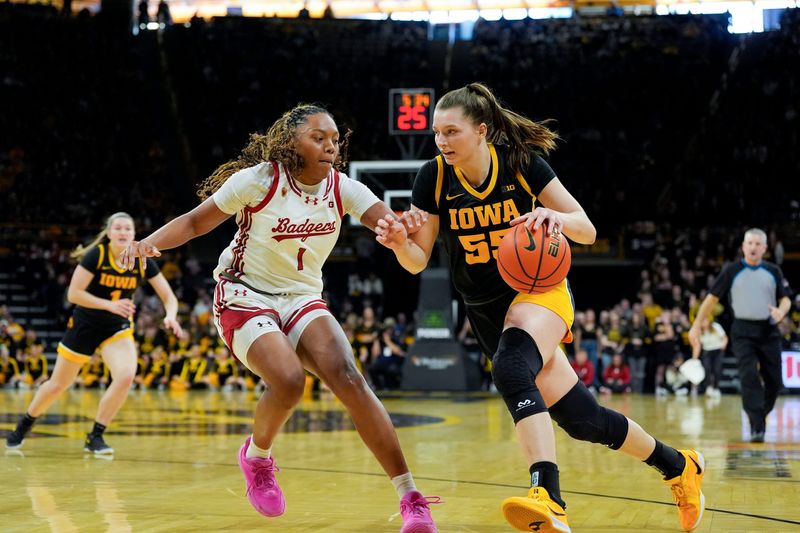 Iowa guard Teagan Mallegni (55) drives to the basket against Wisconsin center Carter McCray (1) during a Big Ten conference game on Sunday, March 2, 2025, at Carver-Hawkeye Arena in Iowa City, Iowa.