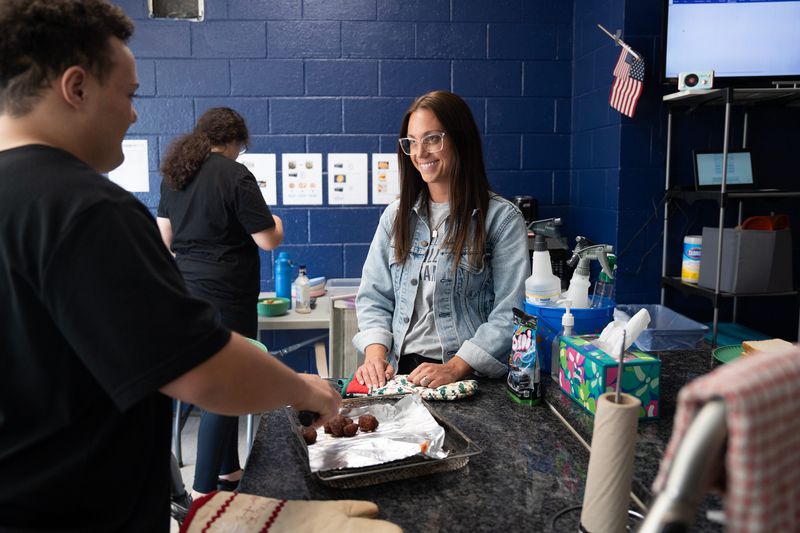 Liz Schwabe, a special education teacher who runs the 18- to 21-year-old transition program at Whitnall High School, assists the students in her program with making lunch on the morning of April 16, 2026, in Greenfield, Wisconsin.