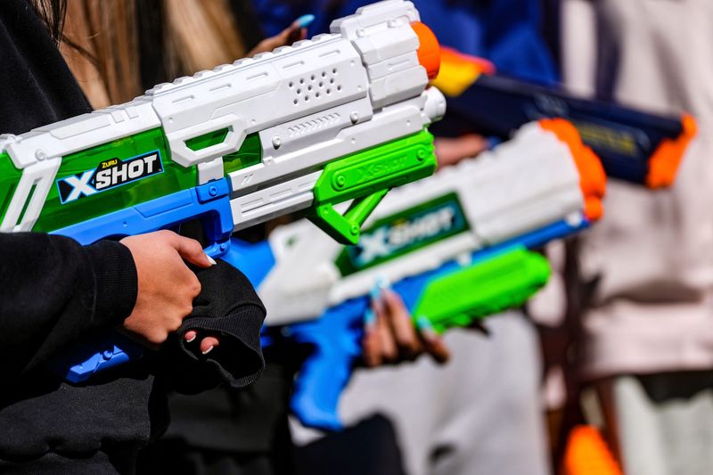 Wet and Wild teammates hold water guns ready to shoot adversaries in Water Wars in Huntington Woods on Monday, April 20, 2026.