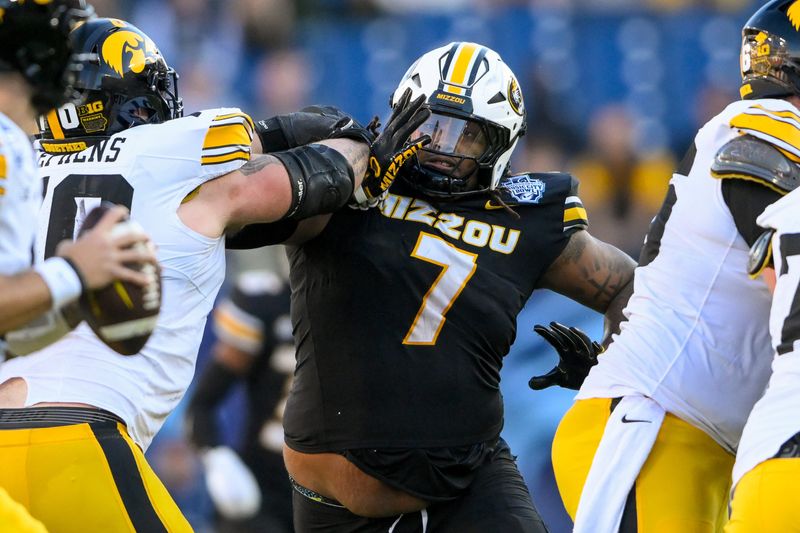 Missouri defensive tackle Chris McClellan (7) rushes Iowa quarterback Brendan Sullivan (1) during the Music City Bowl in Nashville, Tennessee.