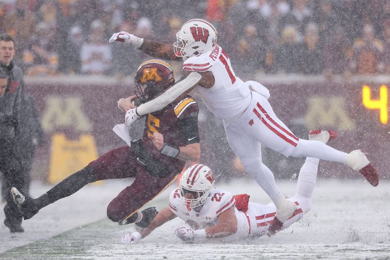 Nov 29, 2025; Minneapolis, Minnesota, USA; Minnesota Golden Gophers quarterback Drake Lindsey (5) runs with the ball as Wisconsin Badgers linebacker Mason Reiger (22) and linebacker Darryl Peterson (17) defend during the first half at Huntington Bank Stadium. Mandatory Credit: Matt Krohn-Imagn Images