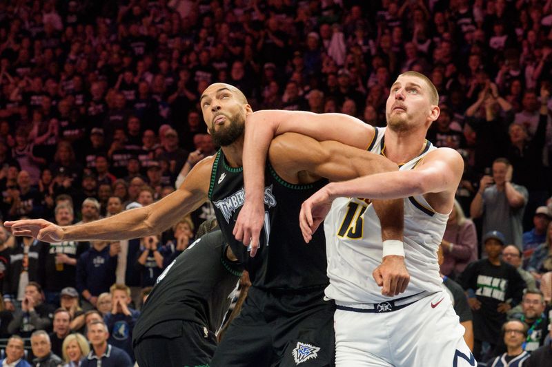 Minneapolis, Minnesota, USA; Minnesota Timberwolves center Rudy Gobert (27) and Denver Nuggets center Nikola Jokic (15) position themselves for a rebound in the fourth quarter at Target Center.