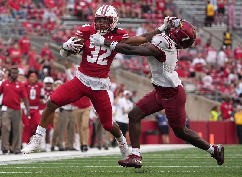 Wisconsin running back Julius Davis (32) stiff arms New Mexico State defensive back Rashad McKinley (12) while picking up 30 yards on a run during the fourth quarter of their game Saturday, September 17, 2022 at Camp Randall Stadium in Madison, Wis. Wisconsin beat New Mexico State 66-7.

Uwgrid17 21