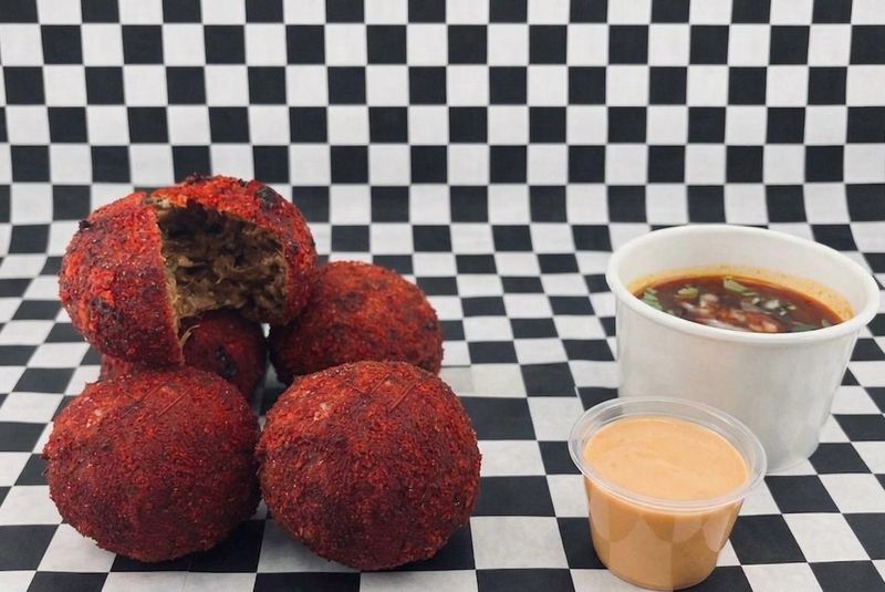 Birria Flamin' Bombs from Fiesta Grill & Cantina are a 2026 Wisconsin State Fair Sporkies finalist. The "bombs" are made with beef birria, cilantro, onion and mozzarella cheese coated in a breadcrumb blend and served with sides of birria consommé and chipotle aioli for dipping.
