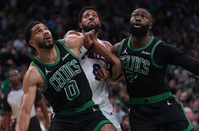Boston Celtics forward Jayson Tatum and guard Jaylen Brown work for a rebound against Philadelphia 76ers forward Paul George in the second quarter during Game 5 of the first round of the 2026 NBA Playoffs at TD Garden in Boston on April 28, 2026.