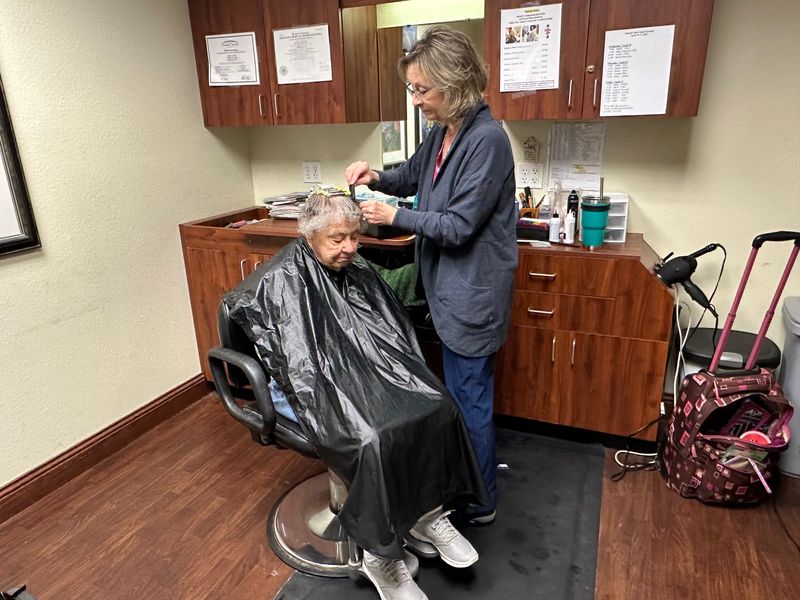 Hairstylist Michelle Kettner works on Alice Schommer’s hair at the Valley VNA hair salon for residents.