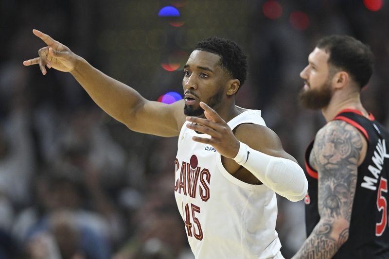 Apr 29, 2026; Cleveland, Ohio, USA; Cleveland Cavaliers guard Donovan Mitchell (45) celebrates his three-point basket beside Toronto Raptors forward Sandro Mamukelashvili (54) in the first quarter of game five of the first round of the 2026 NBA Playoffs at Rocket Arena. Mandatory Credit: David Richard-Imagn Images