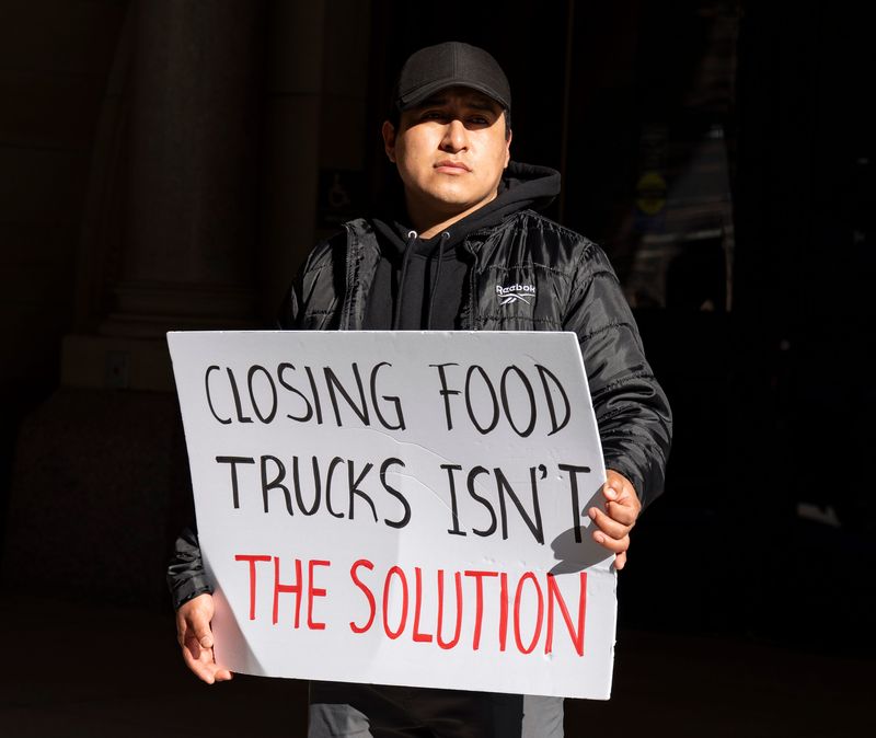Leonel Jimenez Martinez, owner of Tacos Almita, holds up a sign as community members and food truck owners gather outside Milwaukee City Hall to oppose proposed restrictions on food trucks on Thursday April 30, 2026 in Milwaukee, Wisconsin.