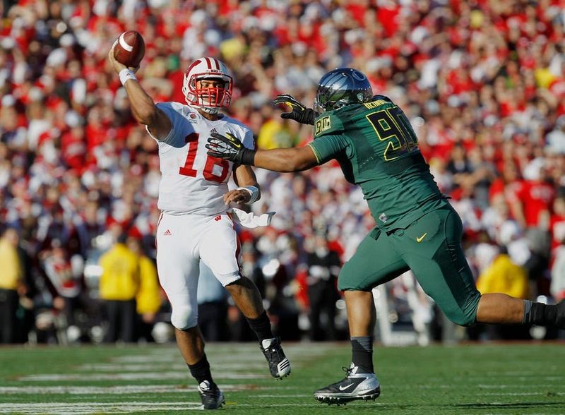 Wisconsin Badgers #16 Russell Wilson throws to #28 Montee Ball on the 5 yard line setting up a touchdown. Oregon Ducks # Ricky Heimuli defends during the 1st quarter. The 98th Rose Bowl Game pits the University of Wisconsin Badgers against the University of Oregon Ducks in Pasadena, CA on 1/2/2012. Photo by Rick Wood/RWOOD@JOURNALSENTINEL.COM