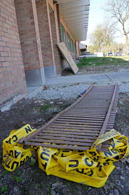 Crumbled yellow caution tape remains at the scene on Friday, May 8, 2026, from last year's Mother's Day fire that claimed the lives of five at Highland Court apartment building at 2725 W. Highland Blvd.