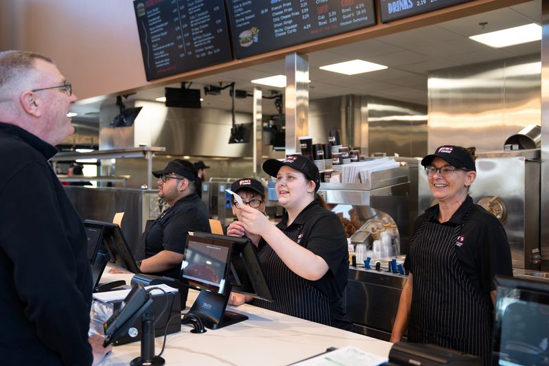Crew member Brianna Kelley helps a customer at Oscar's Frozen Custard Waukesha on the afternoon of May 11, 2026 in the Town of Brookfield, Wisconsin. The custard shop reopened for the first time since a fire destroyed the building in November 2024, and plans a grand opening for May 12.