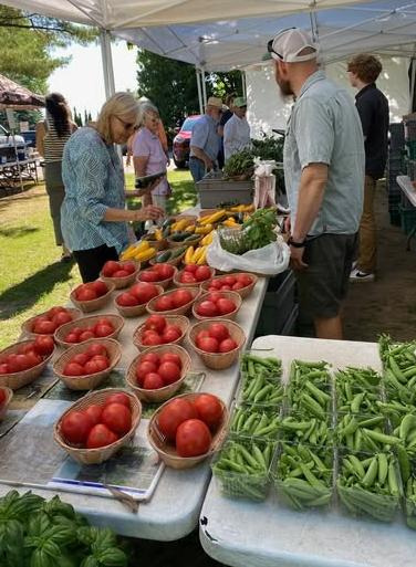 Shoppers check out the goods at the booth for Sully's Produce, one of the more than 30 local vendors who will come weekly to the Jacksonport Farmers Market. Its 2026 season runs from 9 a.m. to 1 p.m. Tuesdays from May 19 through Oct. 13.