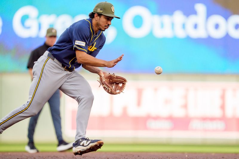 Milwaukee Brewers third baseman David Hamilton (6) fields a ball in the third inning at Target Field on May 15, 2026. Behind him, second-base umpire Junior Valentine donned mismatched pants after a trunk of equipment failed to arrive by game time.