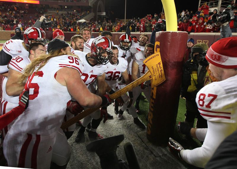 Badgers teammates pretend to chop down the goal post with the Paul Bunyan Ax after Wisconsin's 20-7 win over Minnesota during the Big 10 football game between the Wisconsin Badgers and Minnesota Golden Gophers at TCF Bank Stadium in Minneapolis, Minnesota, Saturday, November 23, 2013.
