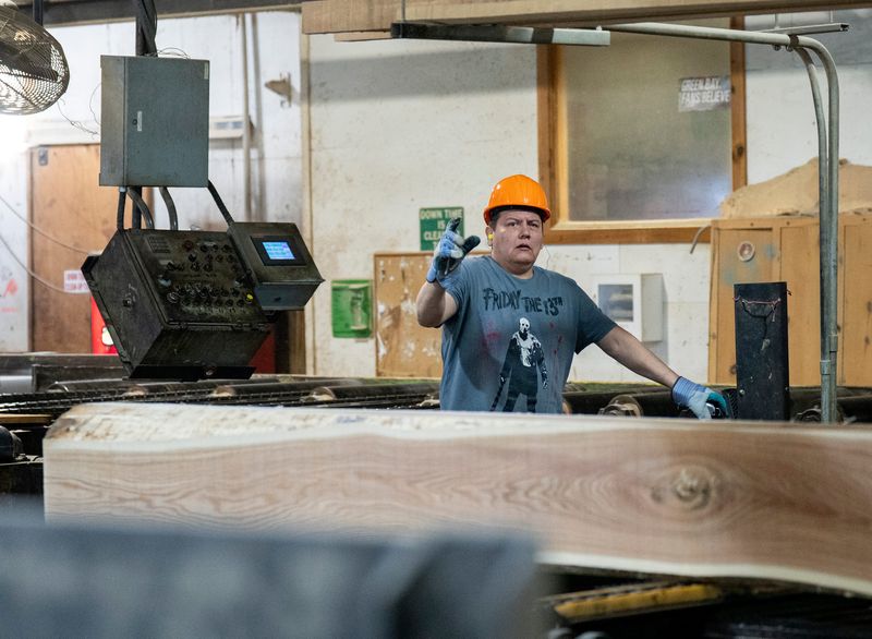 Edger operator Jason Waukau uses the unique “mill talk” sign language to communicate with another worker at the Menominee Tribal Enterprises sawmill on Friday May 15, 2026 in Neopit, Wisconsin.