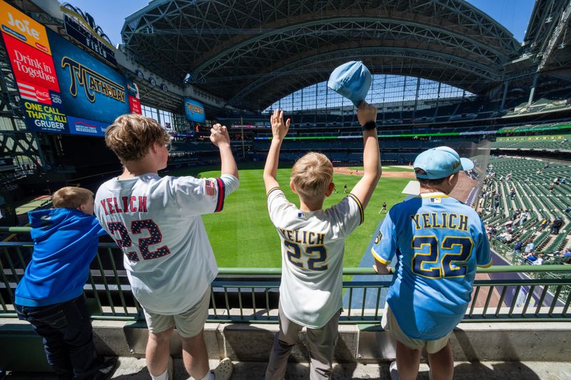 Christian Yelich fans beg for baseballs during warm-ups before a Milwaukee Brewers game.