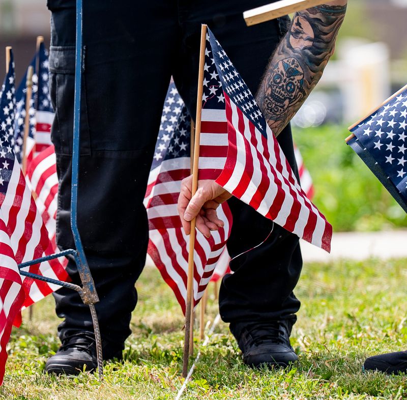 Marine Corps veteran Chad Garcia places a flag at Veterans Park to honor Wisconsin service members who died in wartime for the seventh annual Field of Flags at the War Memorial Center on Tuesday May 19, 2026 in Milwaukee, Wisconsin.
