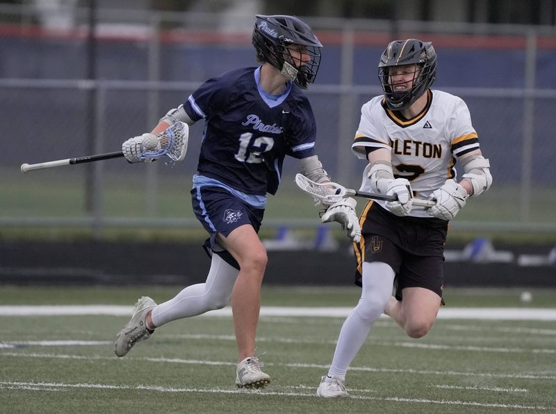 Bay Port High School's Jett Ebert (12) looks to get past Appleton United's Rylan Davia (12) during their boys lacrosse gameTuesday, May 19, 2026, in Appleton, Wisconsin. Appleton United won 12-8.