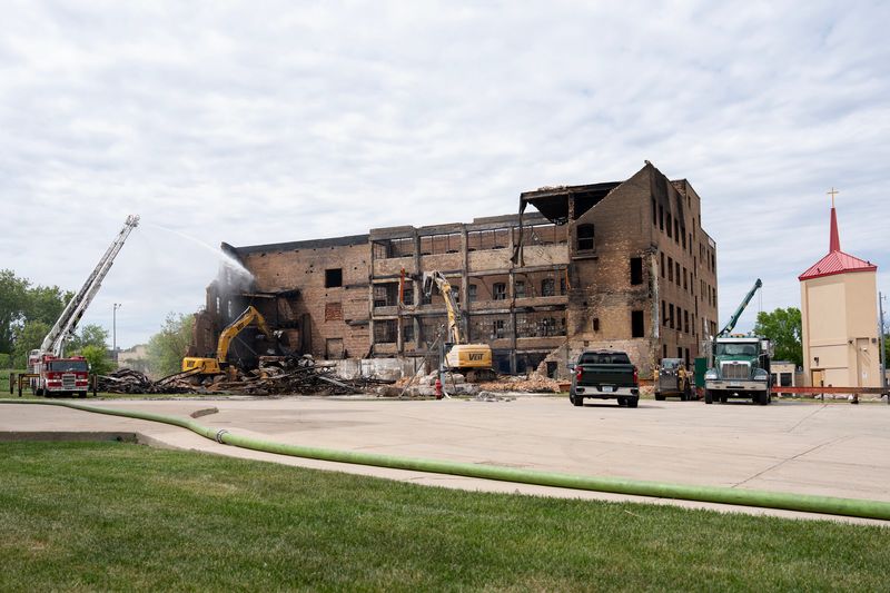 Crews demolish a vacant building on May 21 that caught fire the previous night at the intersection of West Hampton Avenue and North 32nd Street in Milwaukee