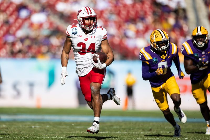 Jan 1, 2024; Tampa, FL, USA; Wisconsin Badgers running back Jackson Acker (34) rushes with the ball for a touchdown during the second half against the LSU Tigers at the Reliaquest Bowl at Raymond James Stadium. Mandatory Credit: Matt Pendleton-USA TODAY Sports