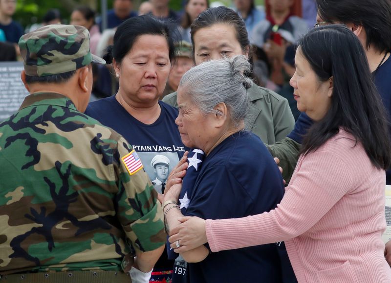 A woman weeps after receiving a U.S. flag for the service of Capt. Vang Lee during Memorial Day program at the Lao, Hmong and American Veterans Memorial in Sheboygan, Wis., on May 25, 2026.