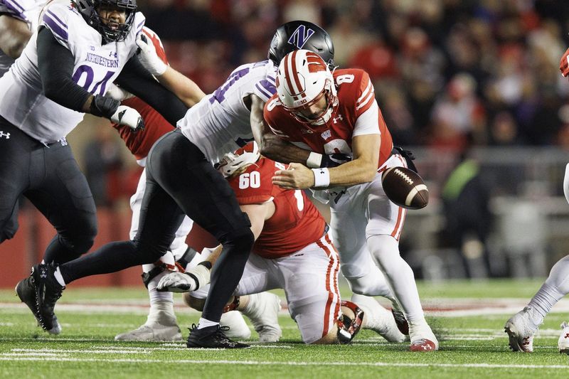 Nov 11, 2023; Madison, Wisconsin, USA; Northwestern Wildcats defensive back Rod Heard II (24) forces Wisconsin Badgers quarterback Tanner Mordecai (8) to fumble the football during the fourth quarter at Camp Randall Stadium. Mandatory Credit: Jeff Hanisch-USA TODAY Sports