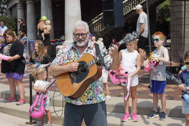 Randy Peterson sings and plays guitar during a midday Out to Lunch concert at Shattuck Park in Neenah.
