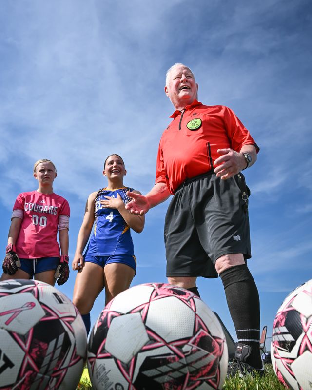 Longtime official John Roever, 80, talks to players and coaches before a girls high school soccer match between Little Chute and Campbellsport on May 26, his second-last match before retiring.