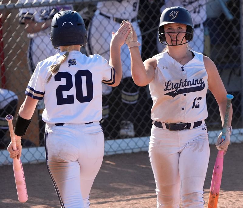 Appleton North High School's Evelyn Frega (20) celebrates scoring a run with Keira Hughes (12) against Menasha High School during their WIAA Division 1 softball regional final Thursday, May 28, 2026, in Appleton, Wisconsin. Appleton Norh won 10-0.