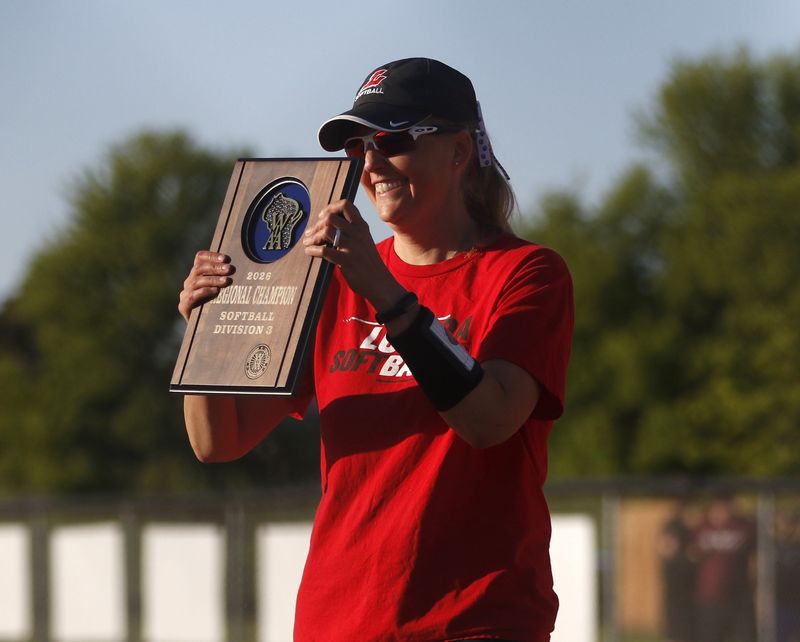 Lomira head coach Stacey Clark holds the regional championship plaque after a win against Winnebago Lutheran at Lomira baseball and softball complex on Thursday, May 28, 2026. Lomira defeated Winnebago Lutheran 8-0 in the regional championship game.