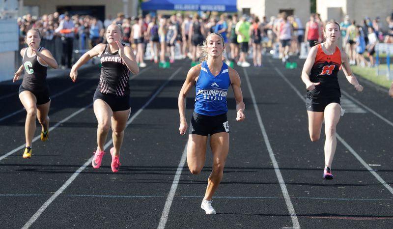 Assumption’s Bella Thomas, center, led the pack during the second heat in the 100 meter run at the Div. 3 Sectional 2 at Hilbert High School, Friday, May 29, 2026, in Hilbert, Wis.