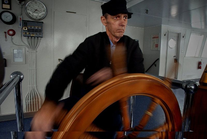 Bob Palmer, wheelsman, keeps a careful eye and steady hand on the rudder as he eyes the horizon, steering the S.S. Badger to avoid some gill nets as the ship leaves Manitowoc in 2003.