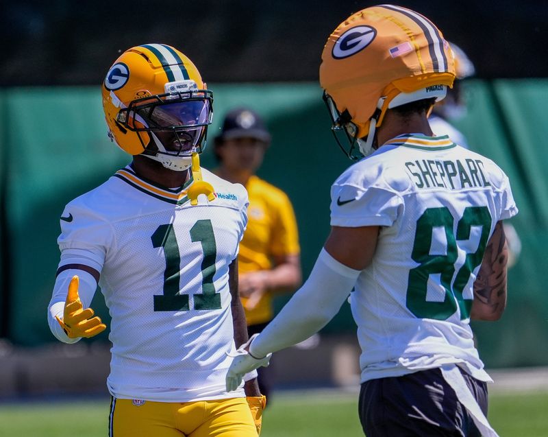 Packers wide receiver Jayden Reed (11) gives encouragement to Will Sheppard (82) after Sheppard slipped and fell while running a route during an OTA practice June 2.