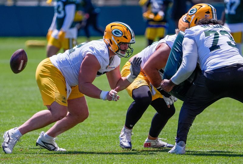 Packers offensive lineman Jager Burton, left, runs through a drill during practice June 2 at Ray Nitschke Field.