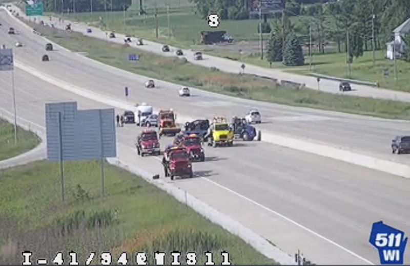 A screenshot of a 511 traffic camera at the scene of the crash. Several tow trucks were removing damaged vehicles from the highway.