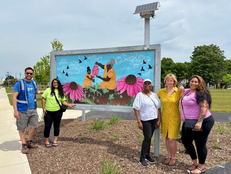 Langston Verdin (left), Mahala Sy, Yvonne McCaskill, Danika Hill-Paulus and Shalina S. Ali stand June 11 by Breath of Promise, a mural in Milwaukee's Melvina Park made with a special type of paint that traps air pollutants.