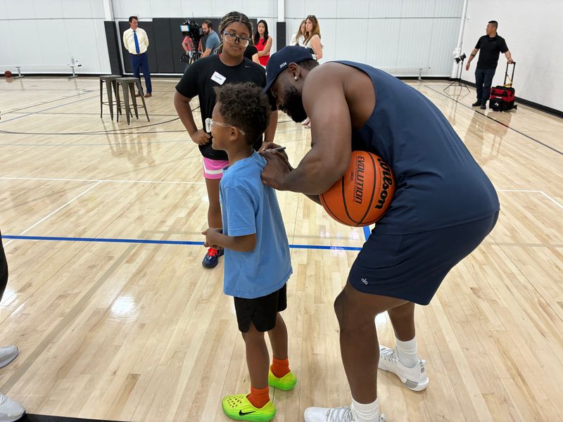 NBA Hall of Famer and Marquette basketball star Dwyane Wade signs Kenson Morris' T-shirt at a basketball camp in Mequon on June 15.