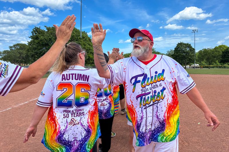 Mark Hare, assistant commissioner of Milwaukee's Saturday Softball League, high-fives his teammates after a game on Saturday, June 13, 2026. Hare joined the league nearly 20 years ago.