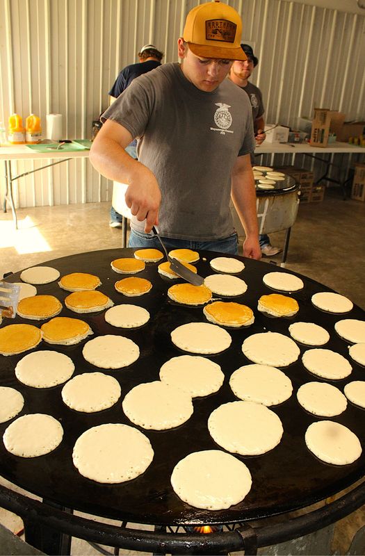 Nick Nelson, an officer with Weyauwega-Fremont High School’s FFA chapter, flips pancakes on a rotating griddle June 21 at the chapter’s annual Breakfast on the Farm fundraiser.
