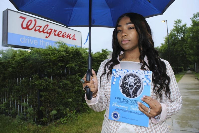 Roberta Steward, founder of Brilliantaires Inc., a nonprofit dedicated to educating and certifying pharmacy technicians, stands in front of the shuttered Walgreens located on North 27th Street and West North Avenue on Wednesday, June 24. Steward holds a workbook she developed as part of the pharmacy technician certification curriculum.