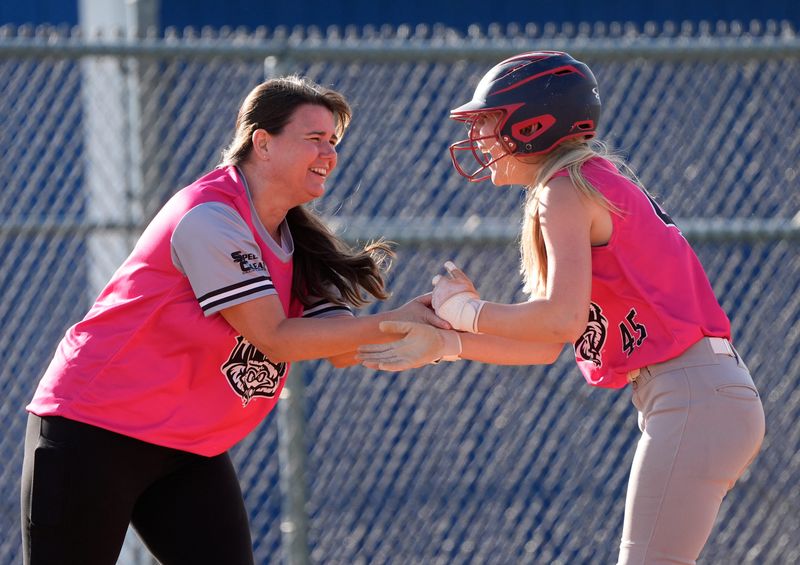 Timber Rattlers manager Sarah Guido congratulates Lily Soda after she hit a triple to drive in a run against Play It Again Sports during the Appleton Little League Major Softball city championship game June 24 at USA Youth Sports Complex.