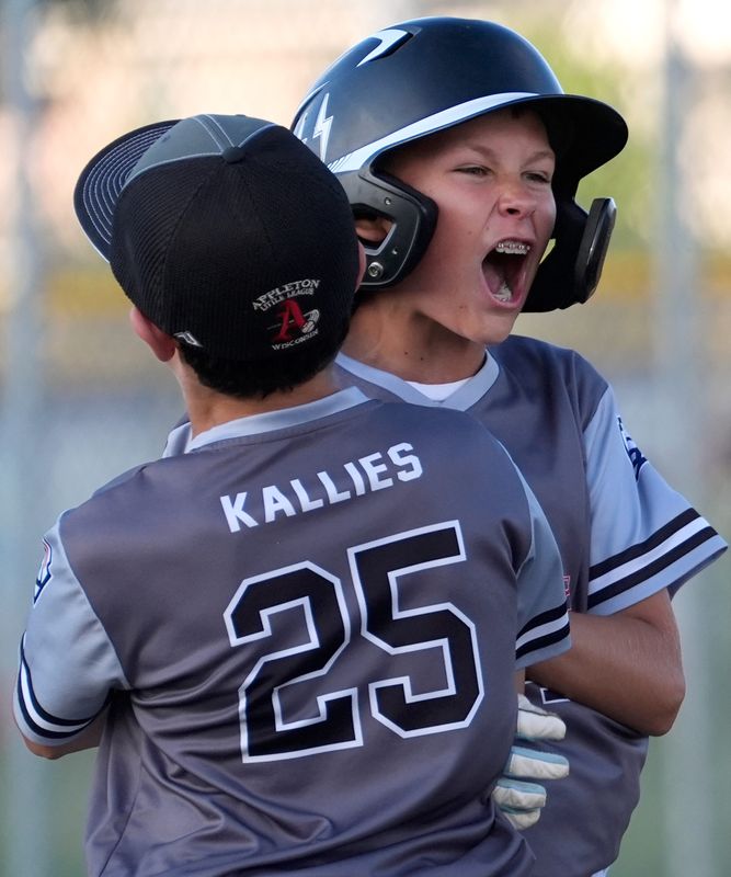American Overhead Door’s Elijah Bowers (44) celebrates with Henry Kallies (25) after hitting a walk-off RBI single against Appleton Firefighters during the Appleton Little League major championship baseball game June 25 at Gromer Field in Appleton.