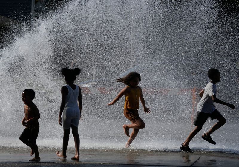 Children get relief from extreme temperatures while playing near the opening of an unauthorized fire hydrant on June 29, near North 21st and West Vliet streets in Milwaukee before the city's Water Works department shut it down. One official said that opening or closing a hydrant can damage underground water mains that could potentially affect the hydrant's ability during an emergency.