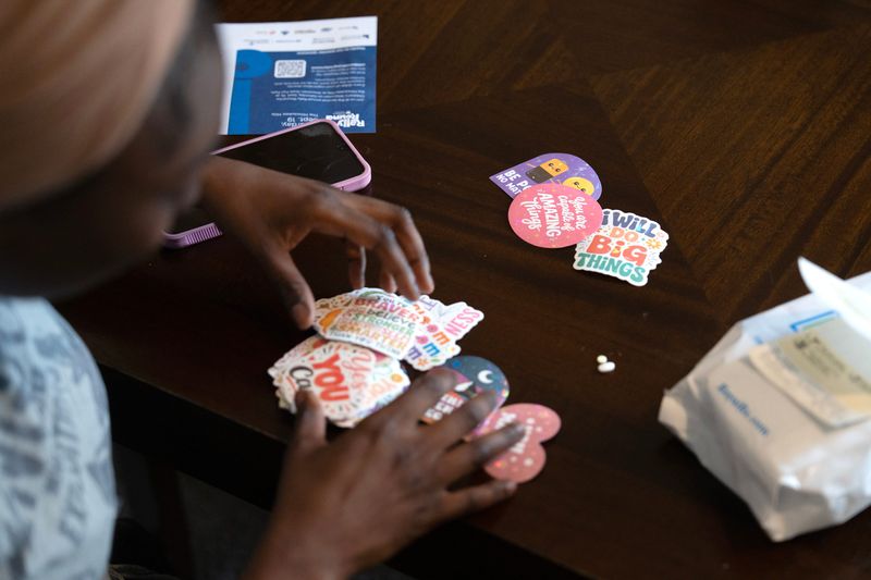 Shaniah Stewart chooses stickers to keep for herself and her son after receiving her long-acting injectable from community care nurse Mara Ahmad on June 30, 2026 in Milwaukee, Wisconsin.